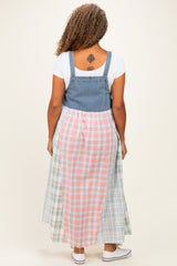 woman wearing a plus-size denim and plaid maxi dress with a fitted top and flowing skirt seen from the back