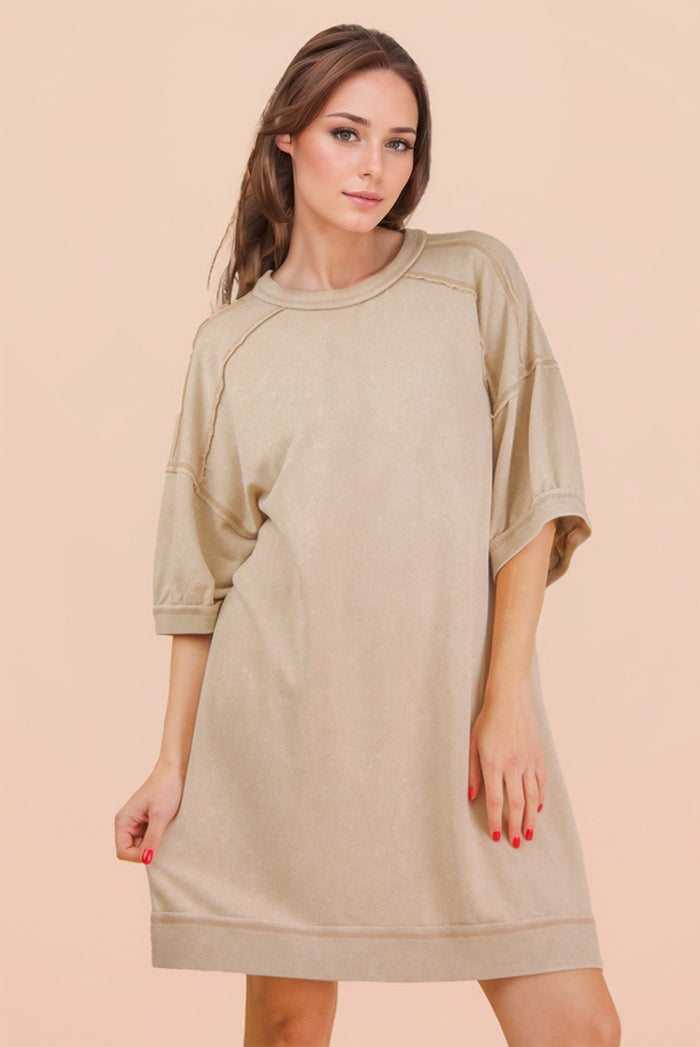 woman wearing a loose-fitting beige oversized t-shirt dress with short sleeves
