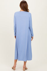 woman wearing a long sleeve blue ribbed maxi dress, viewed from the back, with a flowy silhouette and open back design