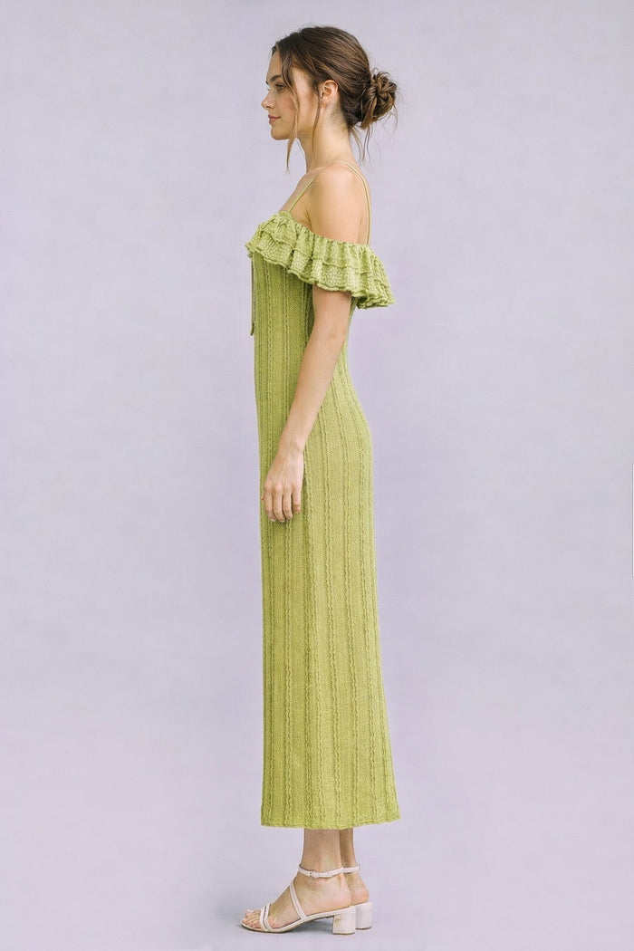 woman wearing a light green off-the-shoulder ribbed maxi dress with ruffle details and strappy sandals