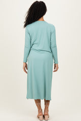 woman wearing a mint green ribbed long sleeve midi dress with a relaxed fit and back pleat detail