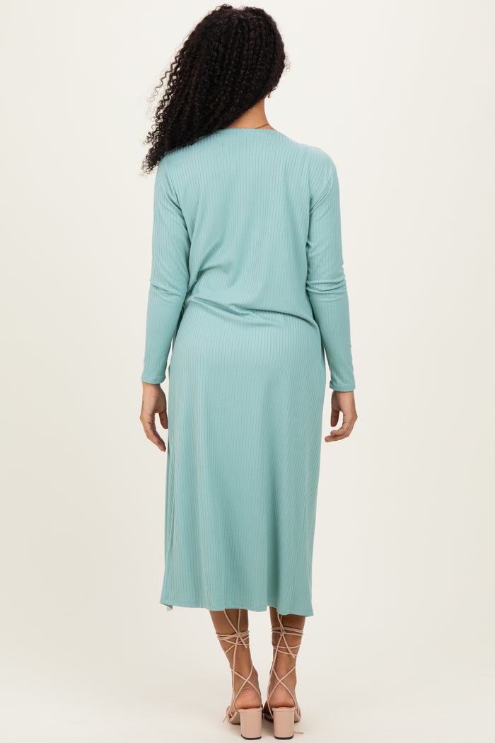 woman wearing a mint green ribbed long sleeve midi dress with a relaxed fit and back pleat detail