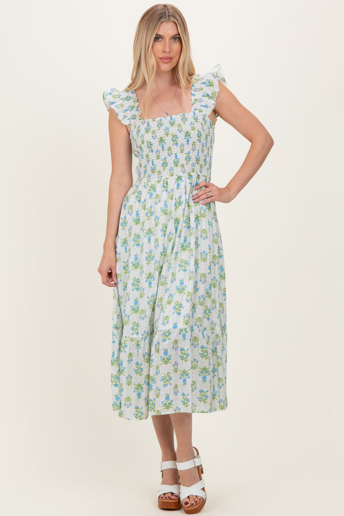 woman wearing a floral print midi dress with ruffle sleeves and smocked bodice