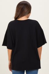 woman wearing a black oversized maternity t-shirt from the back, paired with blue jeans