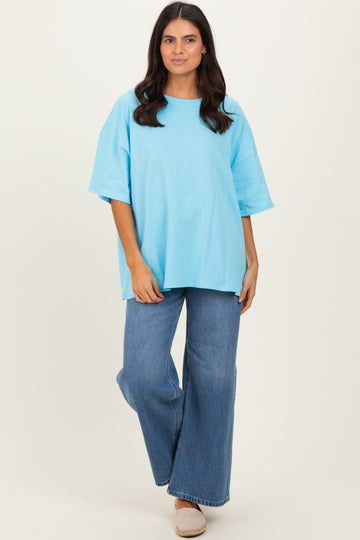woman wearing a light blue oversized t-shirt and wide-leg jeans