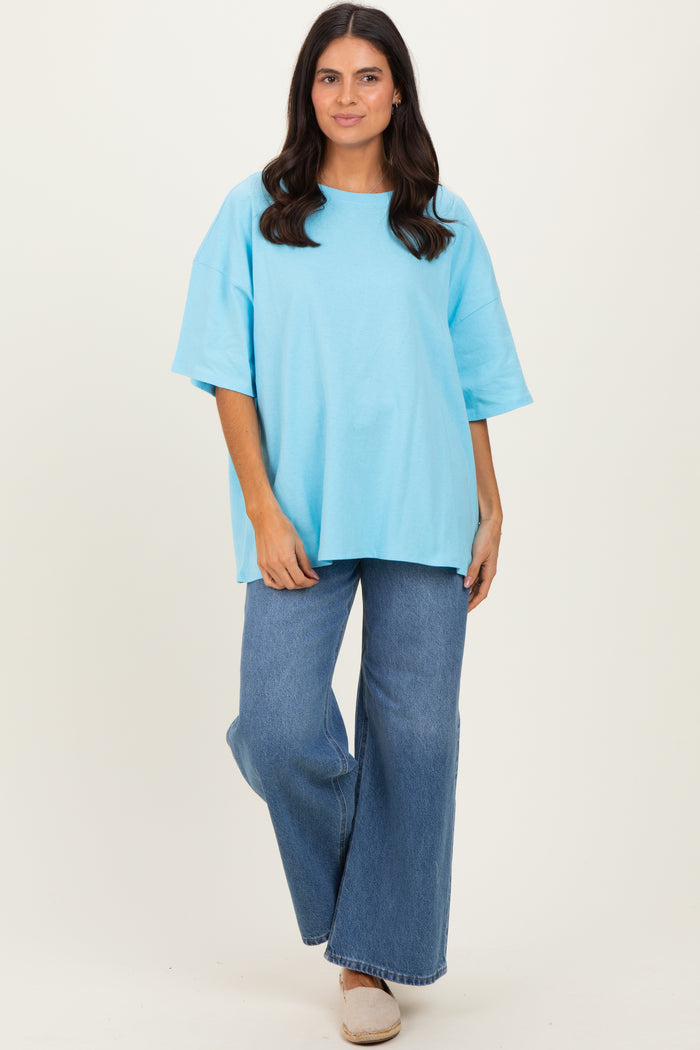woman wearing a light blue oversized t-shirt and wide-leg jeans