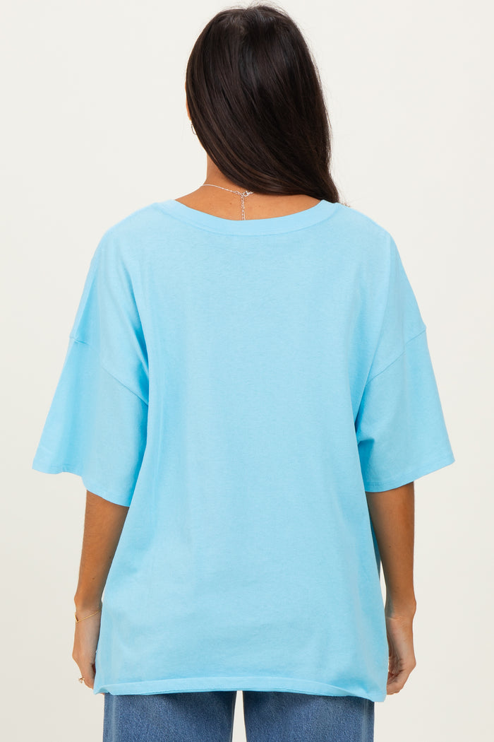 woman wearing a light blue oversized t-shirt viewed from the back, paired with blue jeans