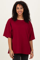 woman wearing a burgundy oversized short sleeve t-shirt with a relaxed fit and round neckline