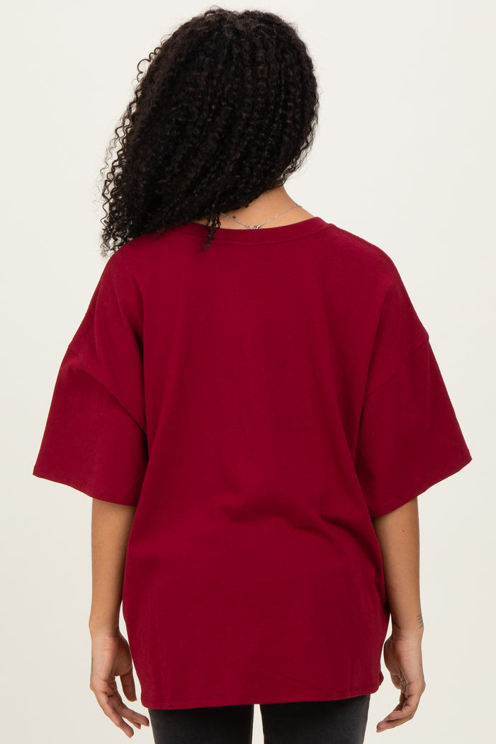woman wearing a burgundy oversized t-shirt with short sleeves, viewed from the back