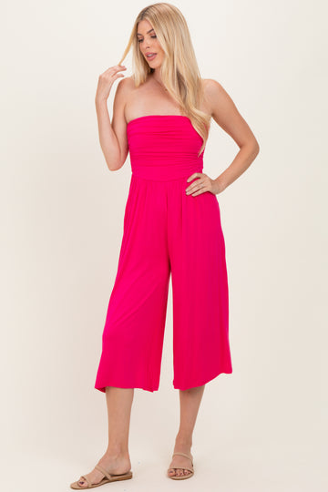 woman wearing a bright pink strapless jumpsuit with wide leg culottes and a relaxed fit
