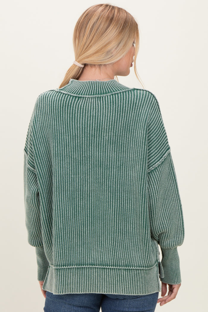 woman wearing a green striped oversized sweater with long sleeves and a relaxed fit, viewed from the back