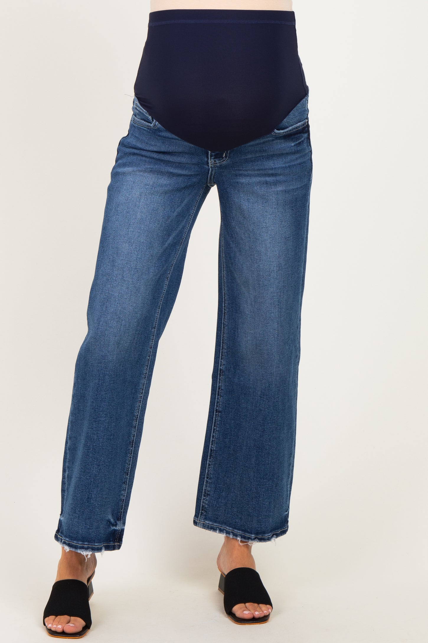 woman wearing dark blue maternity jeans with a wide leg and a navy supportive belly panel