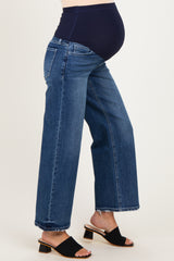 woman wearing a pair of dark blue maternity jeans with a stretchy waistband and frayed hem, showing a baby bump