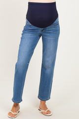 woman wearing a pair of blue maternity jeans with a navy belly panel and standing in sandals