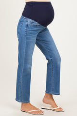 woman wearing dark blue maternity jeans with a belly band and showing her baby bump