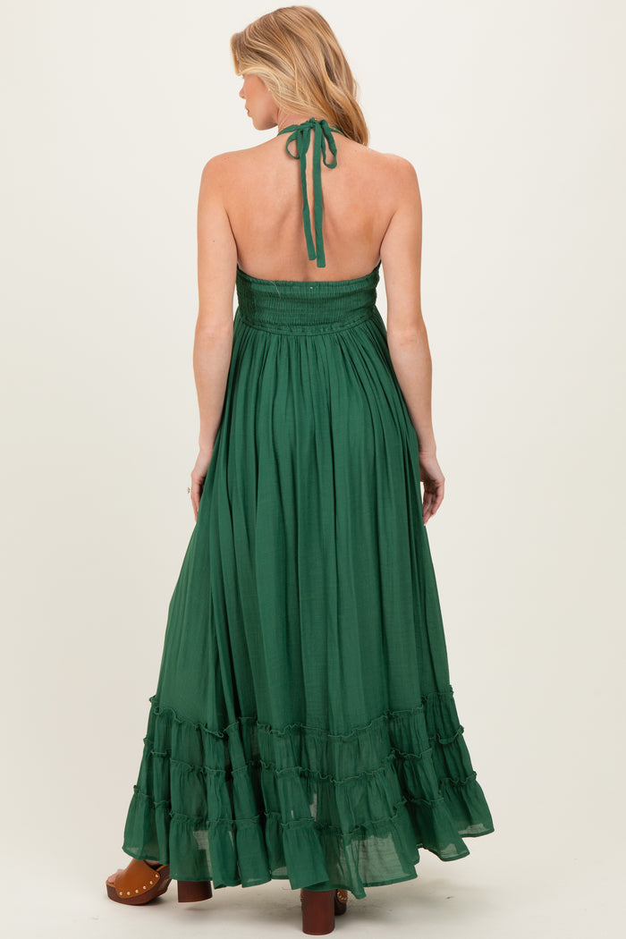 woman wearing a green maternity maxi dress with a smocked bodice and ruffled hem, showing her back