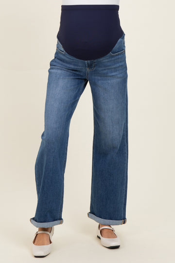 maternity wear dark blue full panel jeans with a wide leg cut and rolled cuffs, model is standing with a visible baby bump