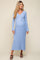 woman wearing a light blue ribbed maternity dress with a tie waist and long sleeves, showcasing her baby bump