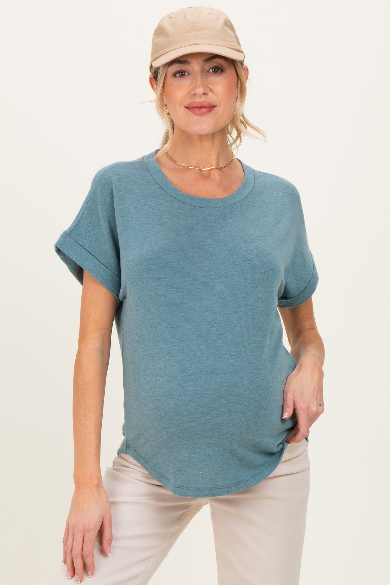 woman wearing a teal maternity t-shirt with rolled sleeves and a subtle curved hem, showing her baby bump