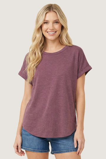 woman wearing a relaxed fit maroon t-shirt with rolled sleeves and denim shorts