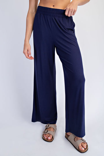 woman wearing navy blue wide-leg trousers with an elastic waistband and casual sandals