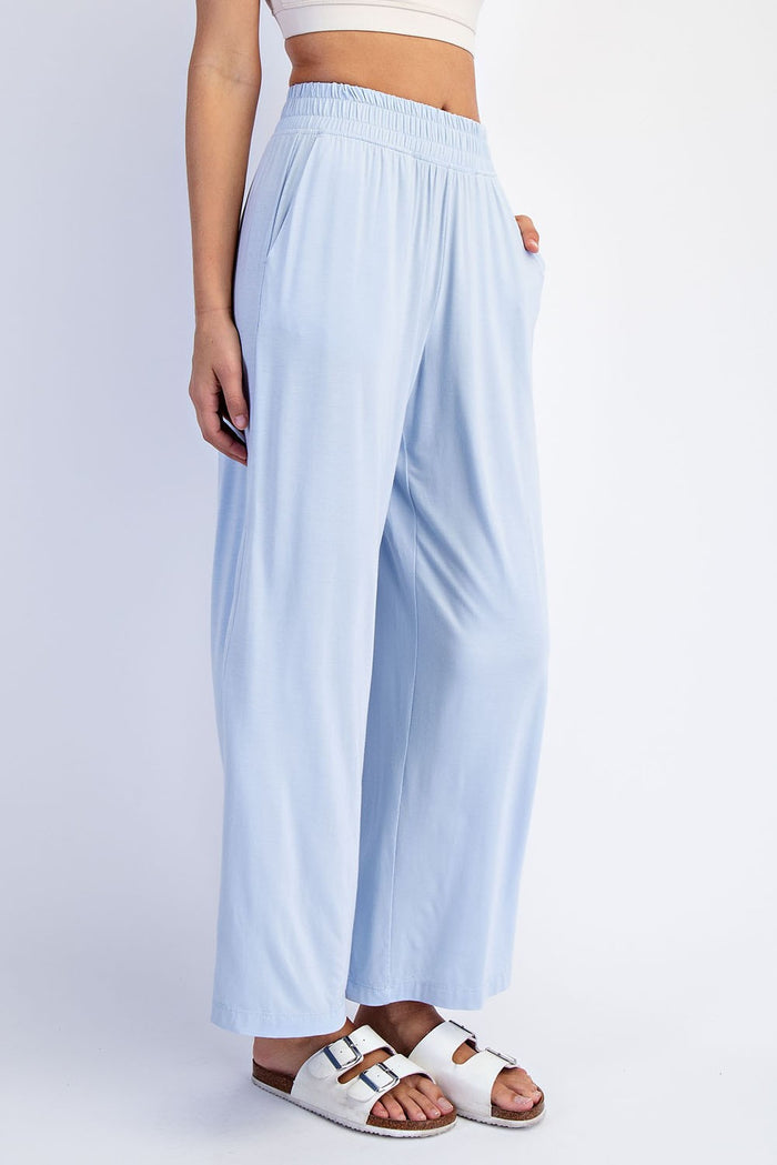 woman wearing light blue wide-leg flowy pants with an elastic waistband and side pockets