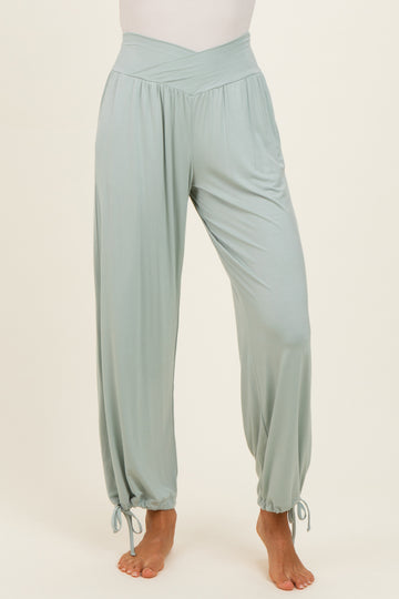 woman wearing light green wide-leg pants with a high waist and tie details at the ankles