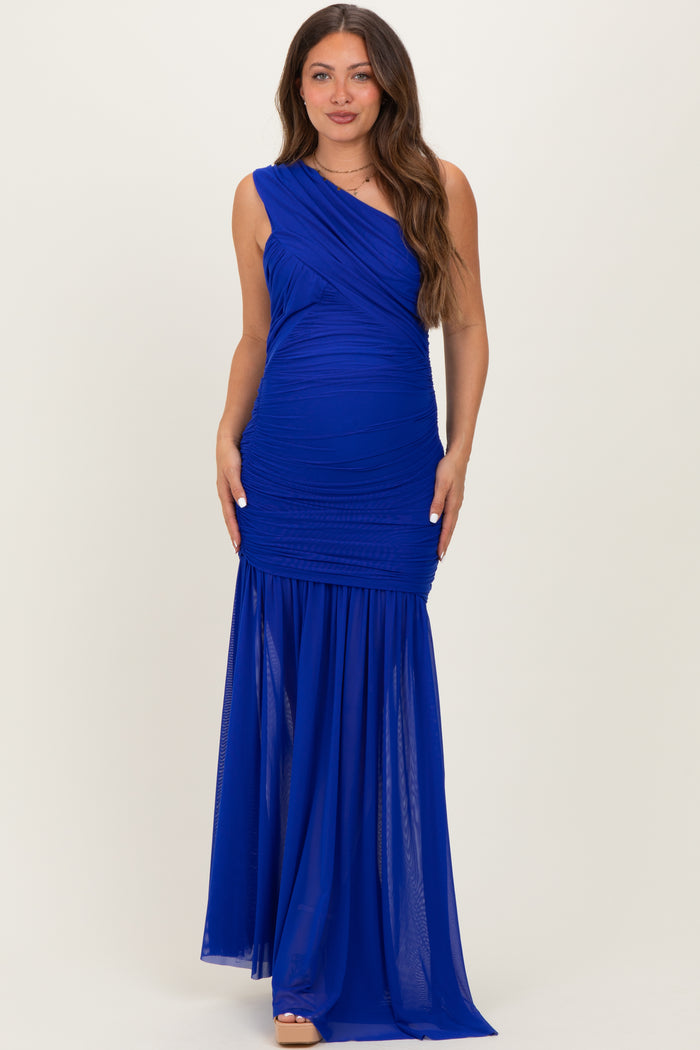 woman wearing a royal blue one-shoulder maternity gown with ruched detailing and a flowing skirt