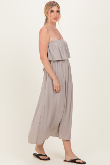 woman wearing a light gray strapless maxi dress with a flowing silhouette