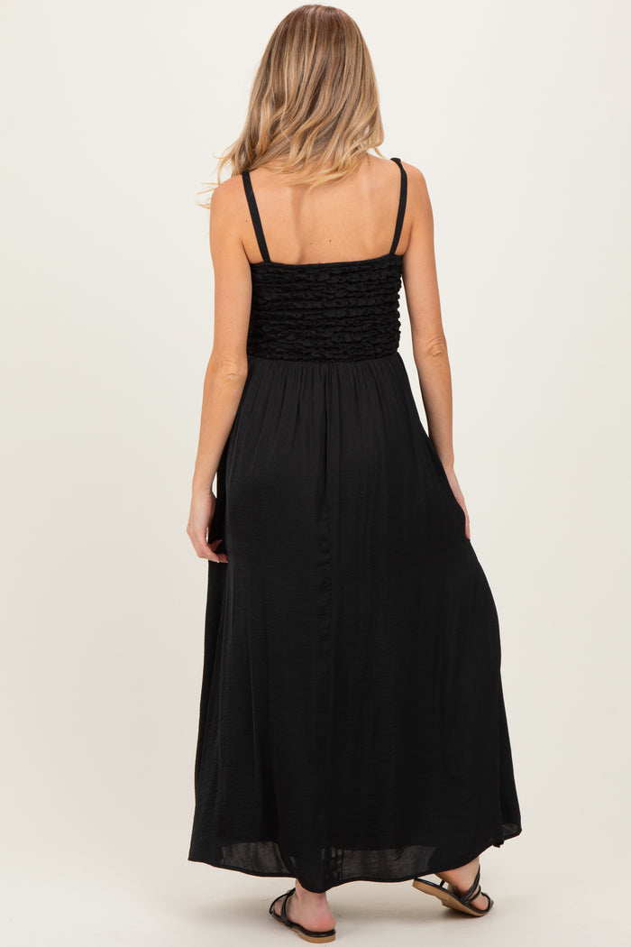 woman wearing a black maternity maxi dress with a smocked bodice and flowing skirt, showing her back