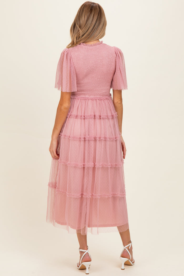 woman wearing a pink tiered maternity dress with short puff sleeves and a smocked bodice
