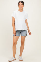 woman wearing a white short sleeve maternity top and denim shorts, showing her baby bump