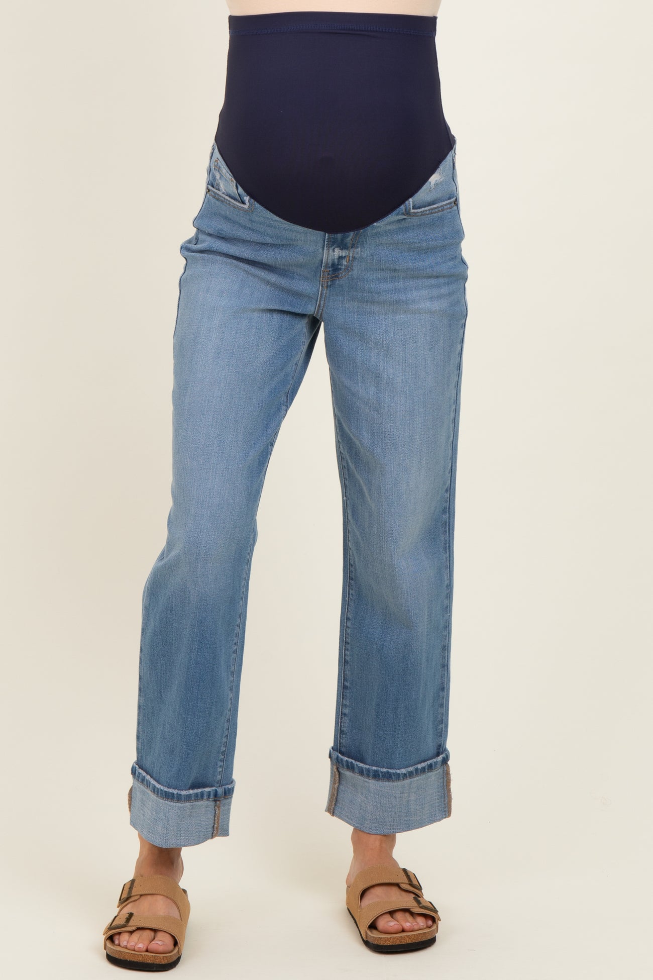 woman wearing blue maternity jeans with a navy belly panel and rolled cuffs