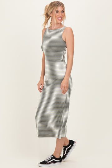 woman wearing a gray and white striped sleeveless midi dress with a fitted silhouette and black sneakers