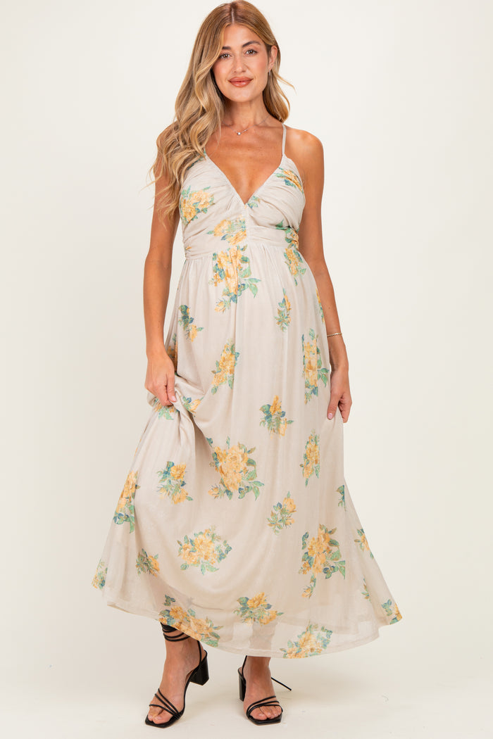 woman wearing a floral maternity maxi dress with a plunging neckline and adjustable straps