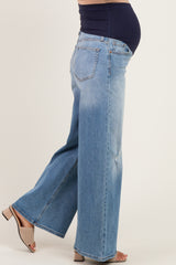woman wearing light blue wide leg maternity jeans with a navy blue waistband and visible baby bump