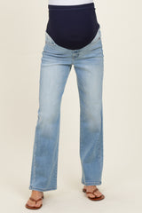 woman wearing light blue maternity jeans with a dark blue over-the-bump waistband and brown sandals