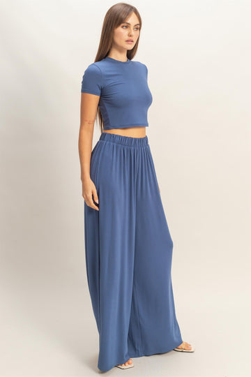 woman wearing a fitted blue crop top and flowy blue wide-leg pants