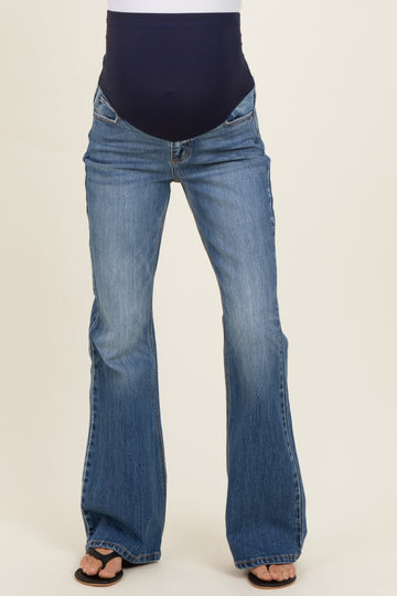 woman wearing blue flared maternity jeans with a supportive belly panel