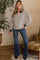 woman wearing a black and white striped maternity polo shirt with slouchy sleeves and flared jeans