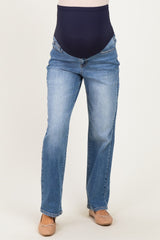 woman wearing a pair of light blue maternity jeans with a navy over-the-bump panel and a straight leg cut