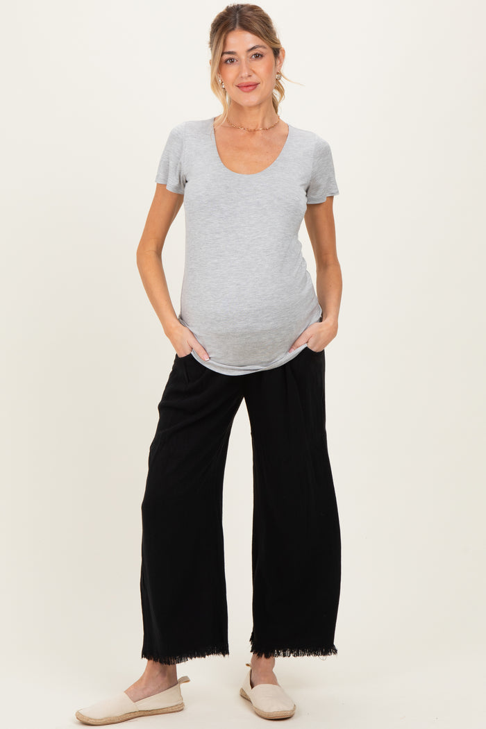 woman wearing a gray maternity t-shirt and black wide-leg maternity pants, showing her baby bump