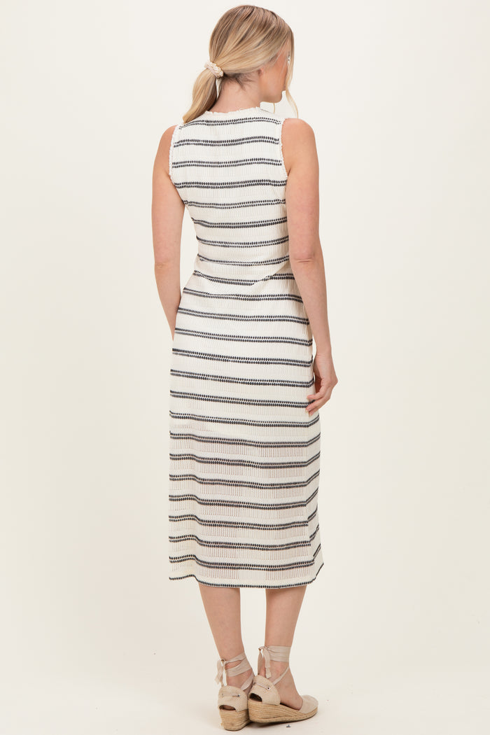 woman wearing a sleeveless white and black striped midi dress with a fitted silhouette and a back view