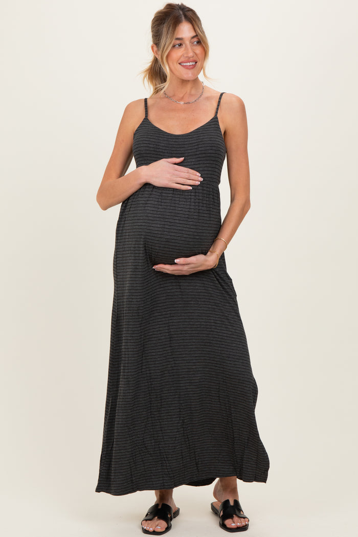 woman wearing a black striped maternity maxi dress and holding her baby bump