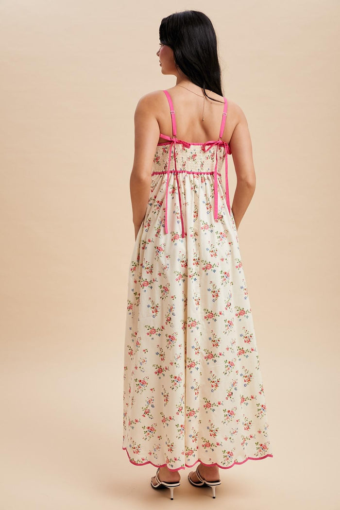 woman wearing a floral maxi dress with pink straps and a gathered back design