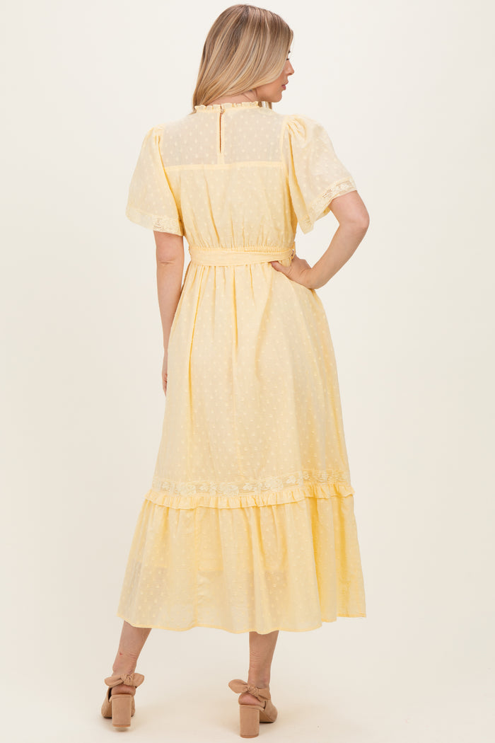 woman wearing a yellow midi dress with short sleeves, a fitted waist, and a tiered ruffle hem