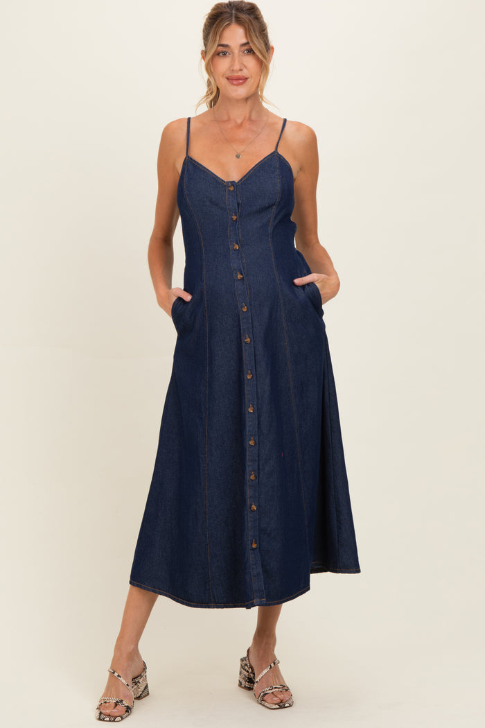 woman wearing a dark denim maternity dress with button-down front and pockets, featuring thin straps and a flowy skirt