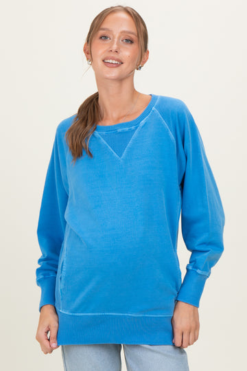 woman wearing a blue long sleeve maternity sweatshirt with a relaxed fit and a baby bump visible