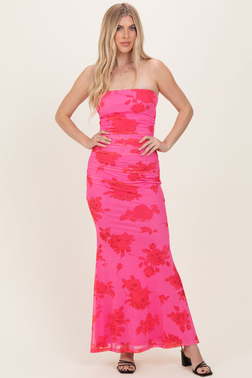 woman wearing a hot pink strapless maxi dress with floral print and ruched detailing