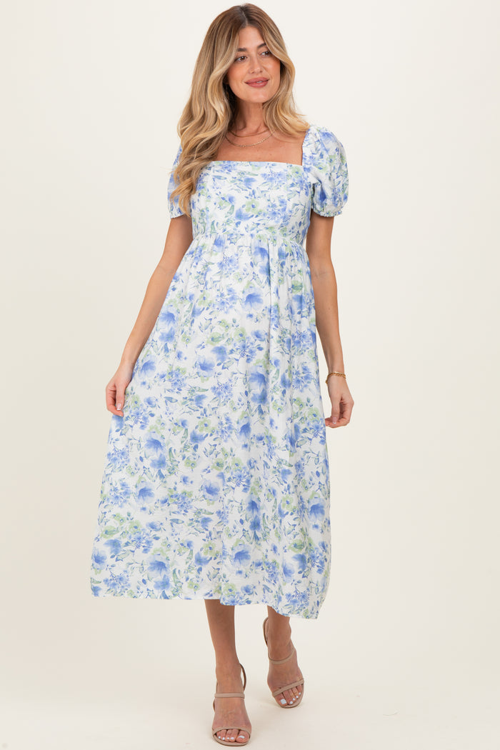 woman wearing a floral maternity maxi dress with puff sleeves and a square neckline, showing no visible baby bump